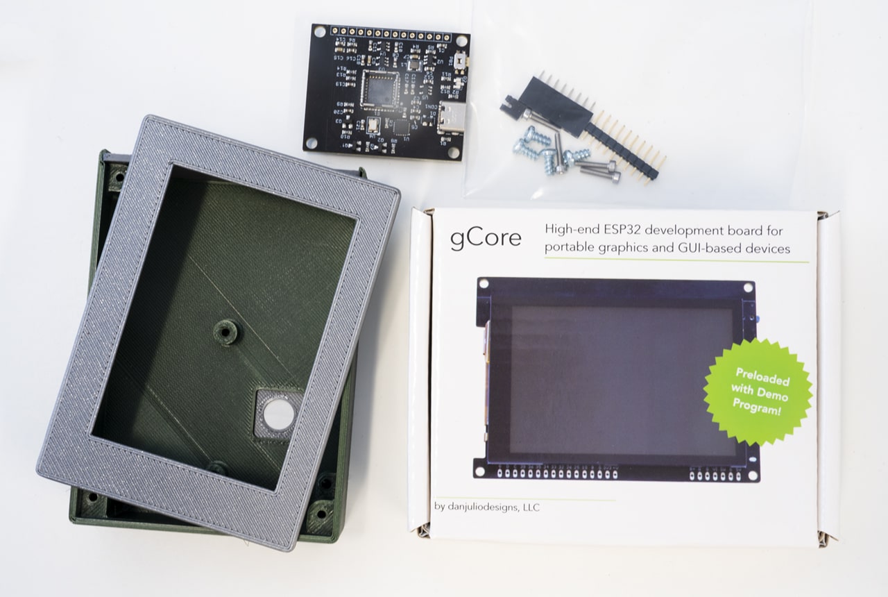 A teardown photo of the tCam Kit: including tCam board, 3D printed encasement and gCore GUI screen, with a bag of screws and assembly help.